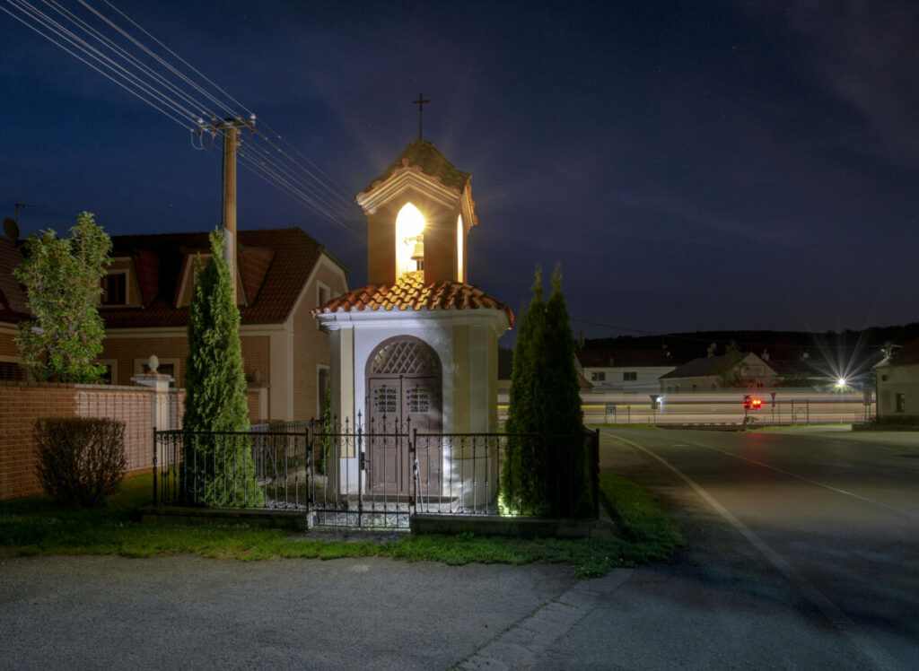 Ikonické nasvícení historicky dochované kaple na návsi v obci Zadní Třebaň.